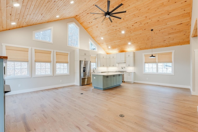 kitchen with light wood-type flooring, wood ceiling, high end refrigerator, and open floor plan