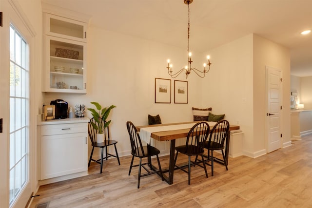 dining space with an inviting chandelier and light hardwood / wood-style floors