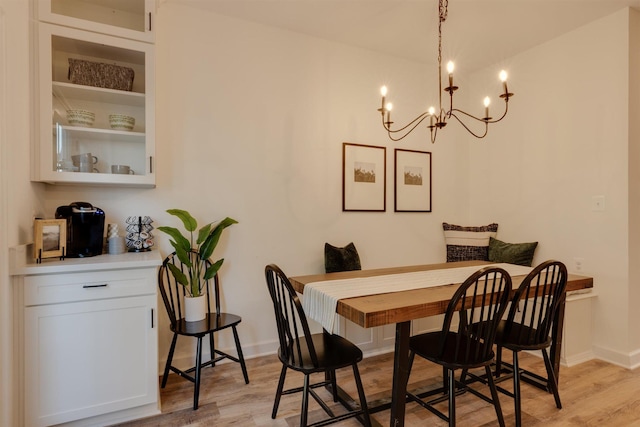 dining space with a notable chandelier and light hardwood / wood-style flooring