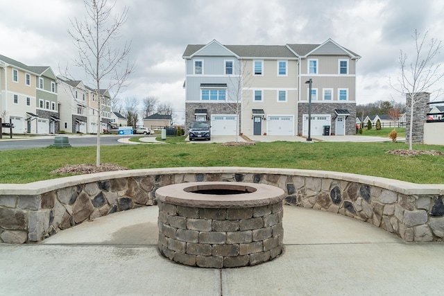 view of patio with an outdoor fire pit and a garage