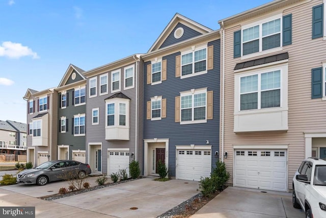 townhome / multi-family property with an attached garage, a residential view, and driveway