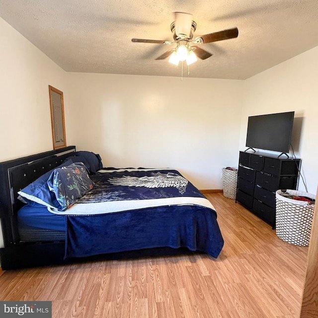 bedroom featuring a textured ceiling, wood finished floors, and a ceiling fan