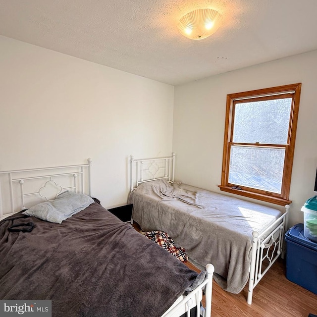 bedroom featuring a textured ceiling and wood finished floors