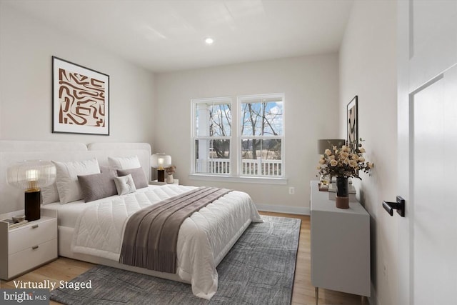 bedroom featuring light wood finished floors, baseboards, and recessed lighting