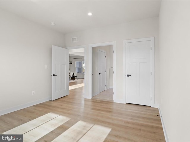 empty room with recessed lighting, baseboards, visible vents, and light wood finished floors