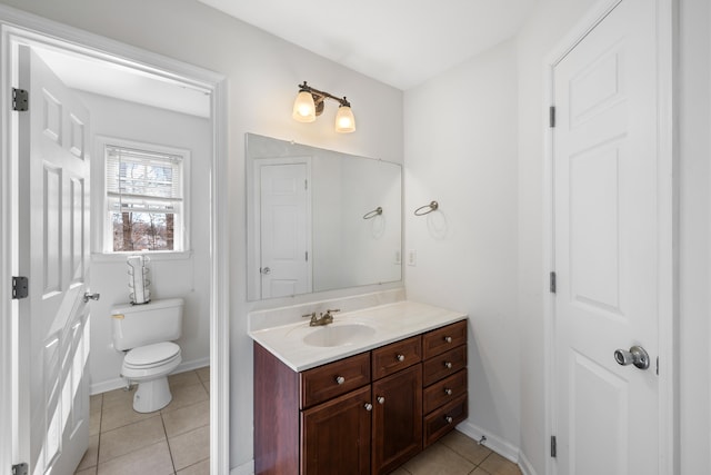 bathroom with toilet, tile patterned flooring, baseboards, and vanity