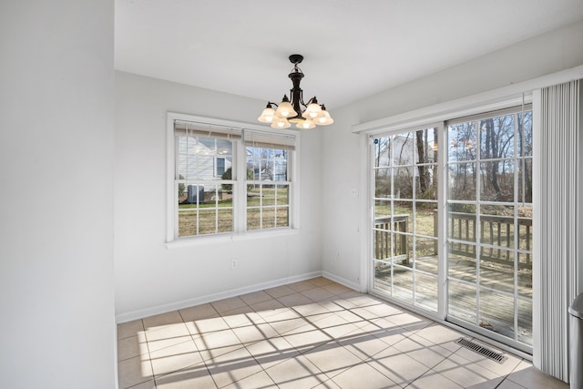 unfurnished dining area with light tile patterned floors, a chandelier, visible vents, and baseboards