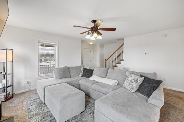 living room featuring a ceiling fan, carpet, stairway, and baseboards