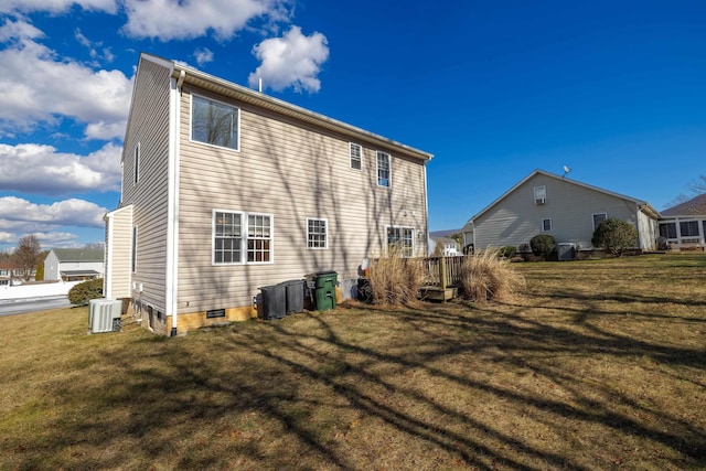 back of house featuring crawl space, a lawn, and cooling unit