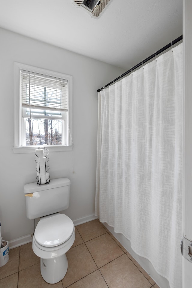 bathroom featuring toilet, baseboards, visible vents, and tile patterned floors