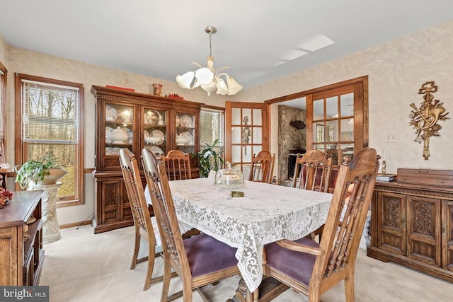 carpeted dining space featuring an inviting chandelier