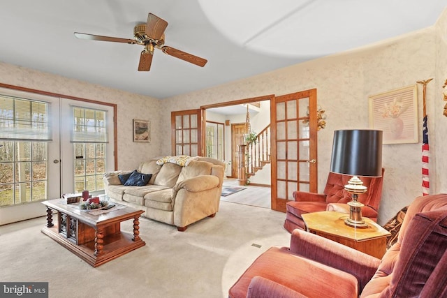 carpeted living room with ceiling fan and french doors