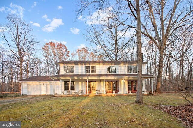 view of front facade with a porch, a garage, and a front lawn