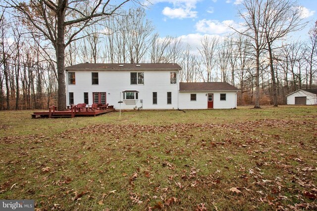 rear view of house with a wooden deck and a lawn