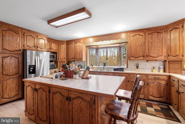 kitchen featuring appliances with stainless steel finishes, a center island, sink, and a kitchen breakfast bar