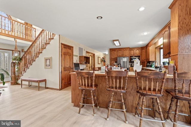 kitchen featuring stainless steel appliances, a healthy amount of sunlight, a breakfast bar, and kitchen peninsula