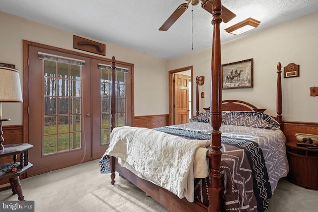 bedroom featuring multiple windows, access to exterior, light colored carpet, and ceiling fan