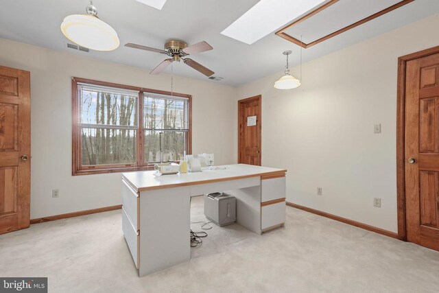 office with light colored carpet, ceiling fan, and a skylight