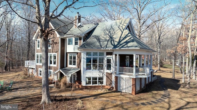 view of front of property with roof with shingles and a chimney