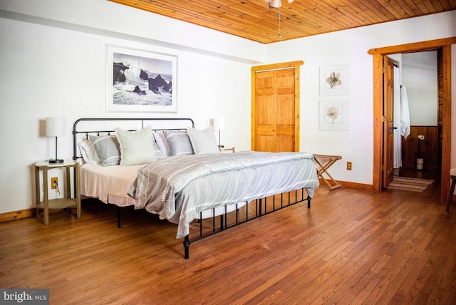 bedroom featuring wood finished floors, wood ceiling, and baseboards