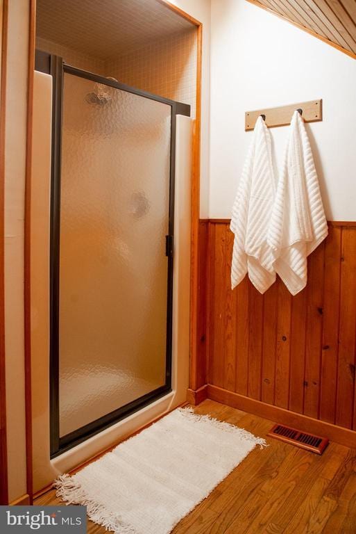 bathroom with wood walls, visible vents, and wainscoting