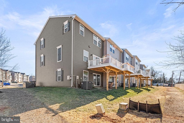 back of property featuring a yard, a wooden deck, and a residential view