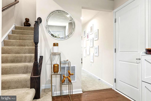 staircase featuring wood finished floors and baseboards