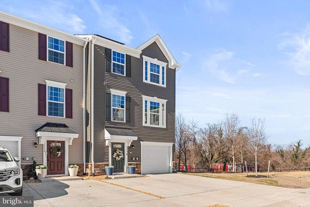 townhome / multi-family property with an attached garage and concrete driveway