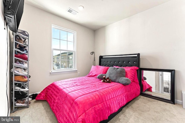 carpeted bedroom featuring baseboards and visible vents