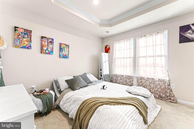 bedroom with baseboards, visible vents, a raised ceiling, ornamental molding, and carpet flooring