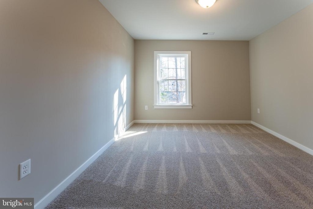 carpeted spare room with baseboards and visible vents