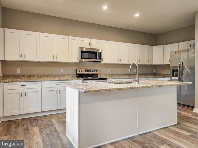 kitchen featuring a sink, stainless steel appliances, light wood-type flooring, and white cabinetry