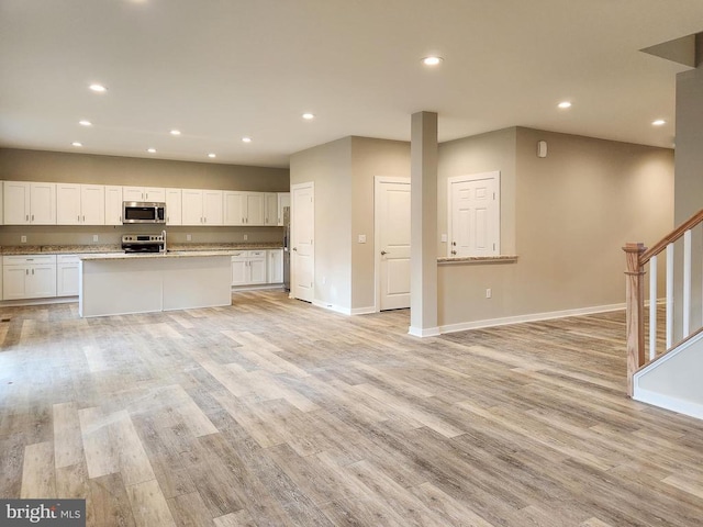 kitchen featuring recessed lighting, baseboards, white cabinets, and stainless steel appliances
