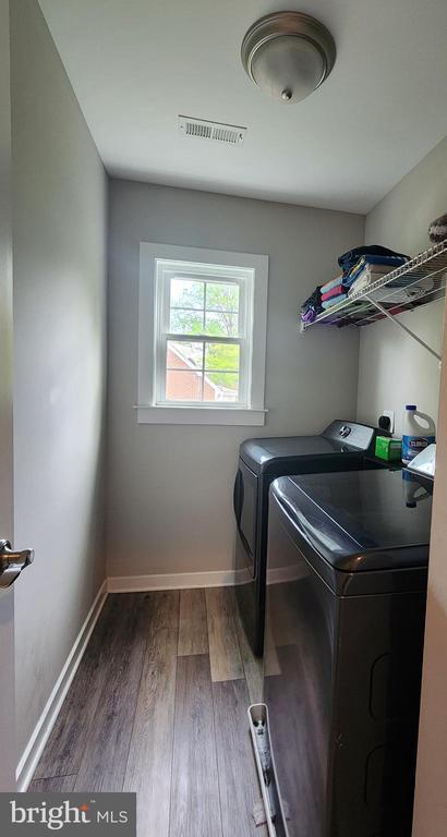 laundry area featuring laundry area, independent washer and dryer, visible vents, dark wood finished floors, and baseboards