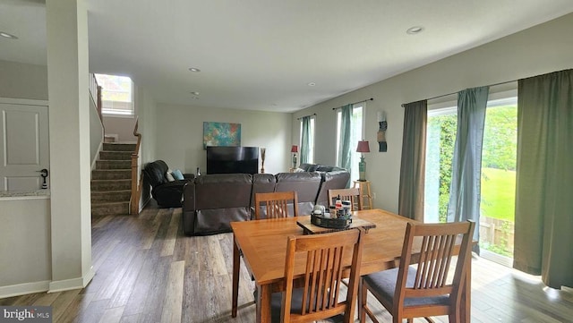 dining space featuring recessed lighting, a healthy amount of sunlight, stairway, and wood finished floors