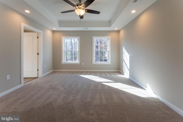 carpeted empty room featuring a raised ceiling, baseboards, a ceiling fan, and recessed lighting