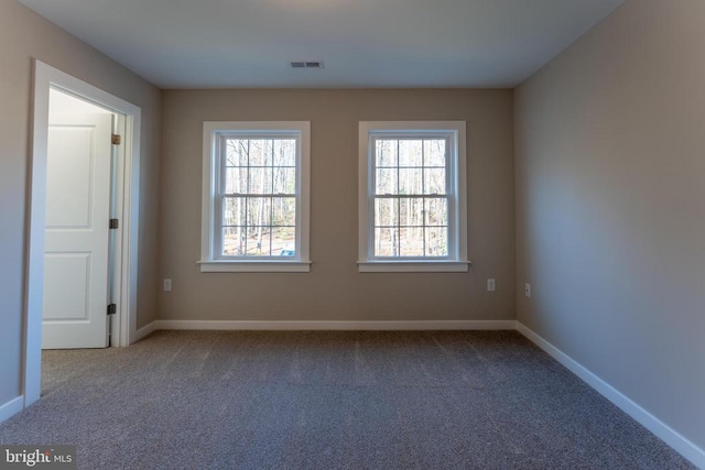 carpeted spare room featuring baseboards and visible vents
