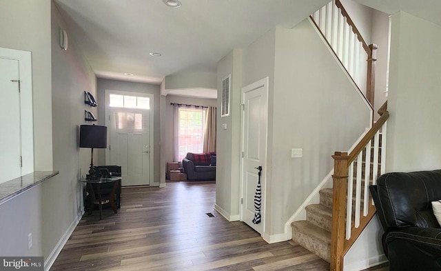 foyer featuring baseboards, stairs, wood finished floors, and visible vents