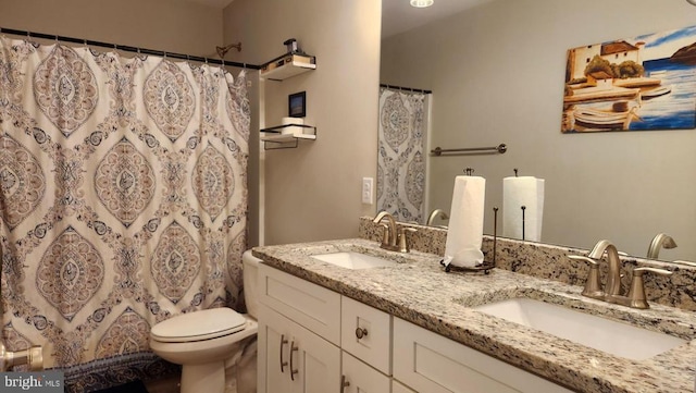 bathroom featuring double vanity, toilet, a shower with shower curtain, and a sink