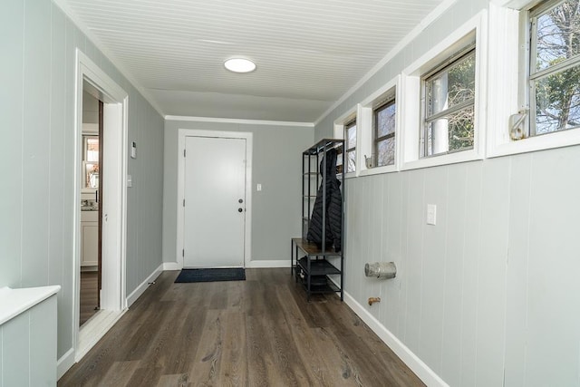 doorway to outside featuring baseboards, ornamental molding, and dark wood-type flooring