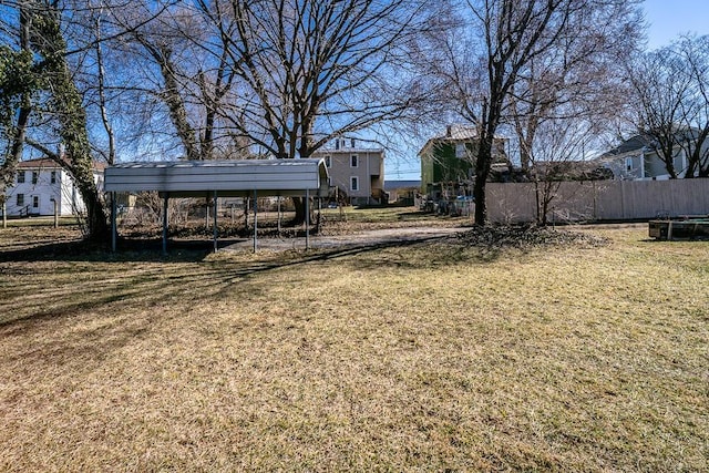 view of yard with a carport and fence