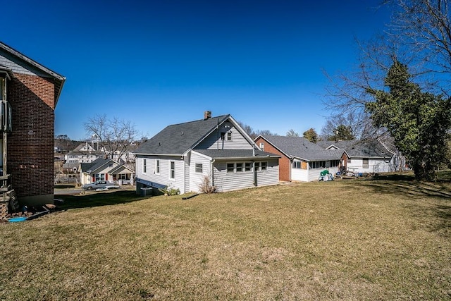 exterior space with a residential view, a lawn, and a chimney