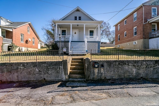 view of front facade with a fenced front yard, stairway, and covered porch