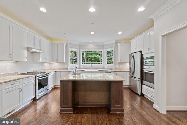 kitchen featuring white cabinetry, crown molding, stainless steel appliances, and a center island with sink