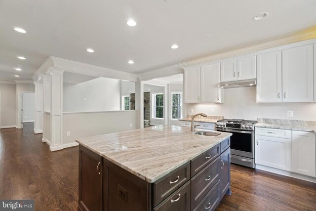 kitchen featuring white cabinetry, stainless steel range with gas stovetop, a kitchen island with sink, and sink