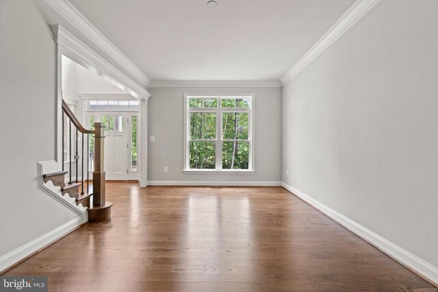 unfurnished living room featuring hardwood / wood-style flooring and ornamental molding