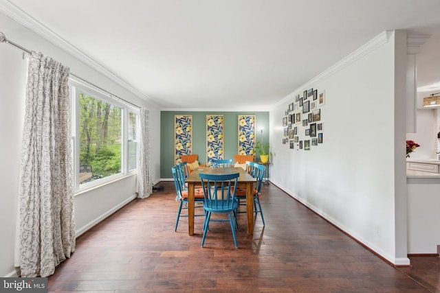 dining room featuring crown molding, baseboards, and wood finished floors