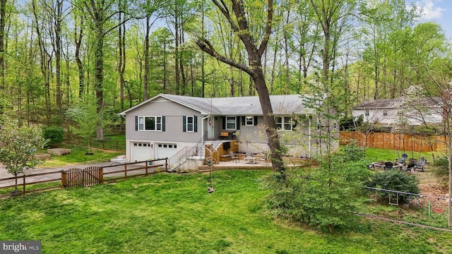 exterior space with a lawn, an attached garage, and fence