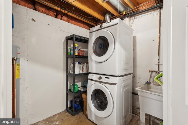 clothes washing area featuring laundry area, a sink, and stacked washer / dryer