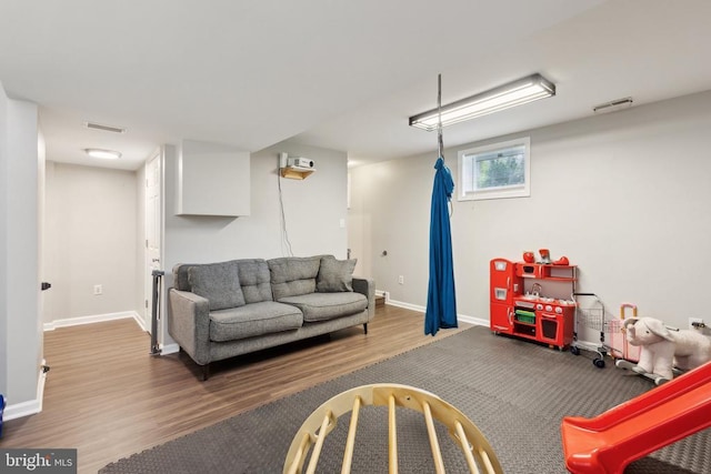 living room featuring visible vents, baseboards, and wood finished floors